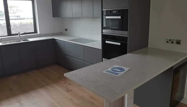Modern grey handleless kitchen with quartz worktops fitted by S.L. Builders LTD