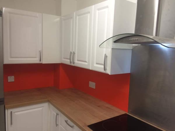 White kitchen with oak worktops and red splashback fitted by S.L. Builders LTD